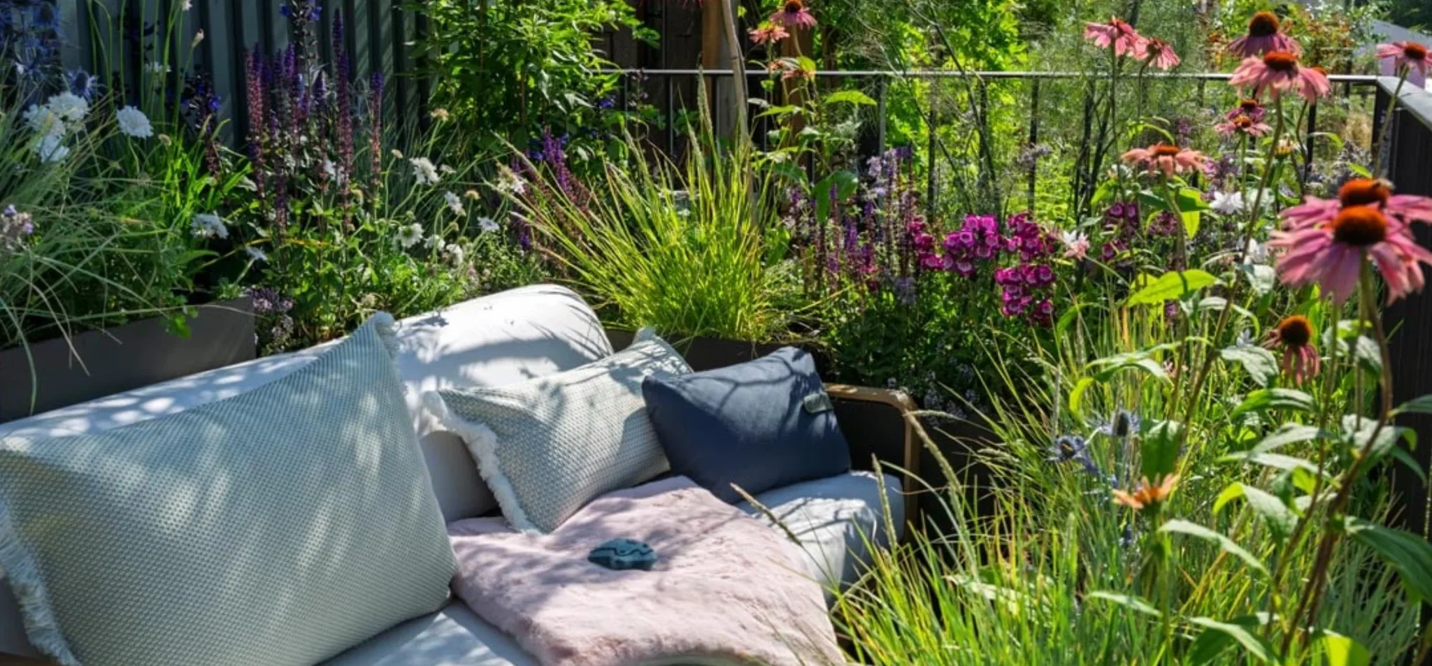 Plant-rich courtyard seating surrounded by grasses and flowers